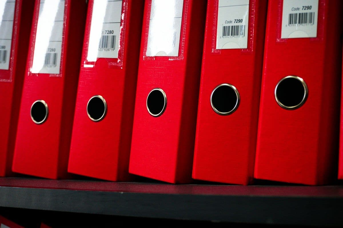 Row of red document binders on a shelf