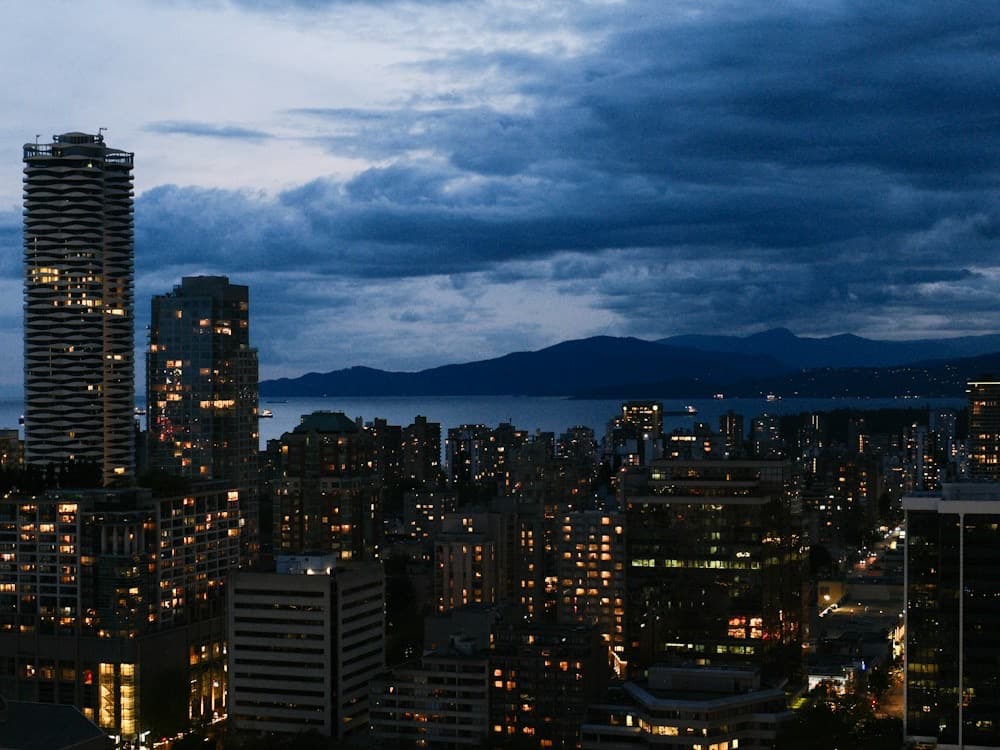 Downtown Vancouver towers at dusk with the North Shore mountains behind
