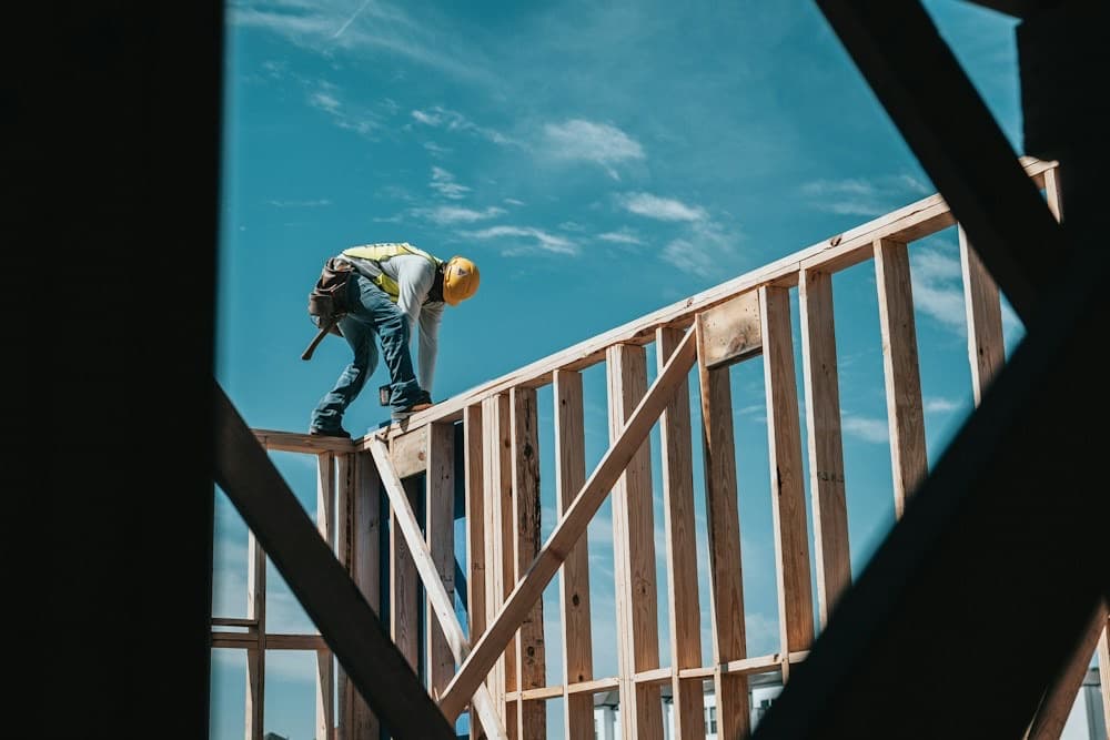 Construction worker framing the wooden wall of a new house
